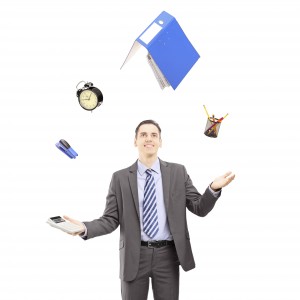 Young businessman in a suit juggling with office supplies