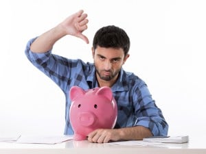 sad worried man in stress with piggy bank in bad financial situation