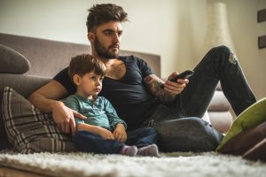 Dad and son watching movies together at home.