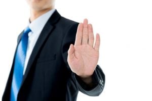 stop sign businessman holding up hand stop gesture