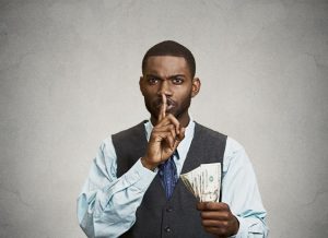 corrupt guy businessman holding dollar bill in hand showing shhh sign