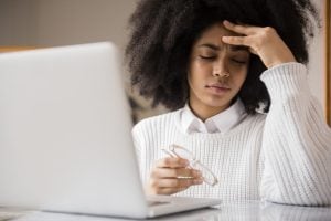 Frustrated African American woman holding eyeglasses near laptop face palm, d’oh, sad, embarrass, diverse, stress