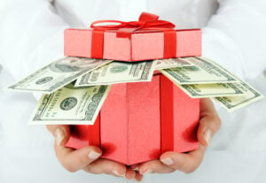 money bonus A red gift box with hundred dollar bills