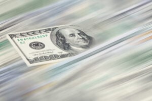Money transfer concept – $100 US dollar banknote with blurred motion effect.