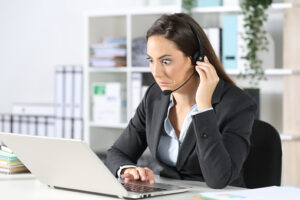 Confused telemarketer looking at laptop at office