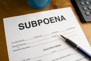 Subpoena form with a pen on a wooden desk