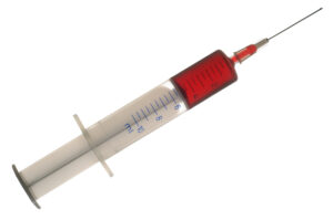 Medical syringe with red liquid, isolated on white