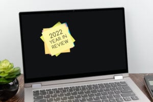 Adhesive note with text 2022 year in review on laptop screen