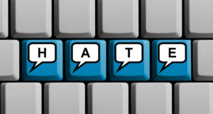 Hate speech online – Speech bubbles on computer keyboard