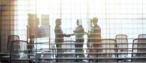 Business people standing in conference room shaking hands