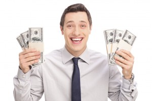 Joyful young man holding six stacks of money