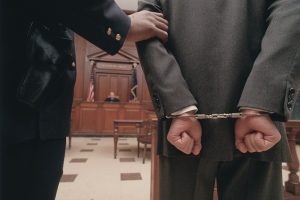 Businessman in handcuffs in courtroom