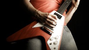 A person playing a rock and roll guitar