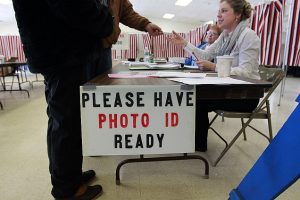 ALLENSTOWN, NH - FEBRUARY 9: At a polling place in Allenstown, N.H., voters show identification before voting in the New Hampshire presidential primary election on Feb. 9, 2016. (Photo by Suzanne Kreiter/The Boston Globe via Getty Images)