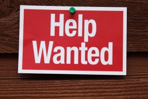 Help Wanted Sign on wooden background