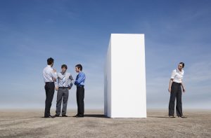 Businessmen beside wall outdoors with woman on other side