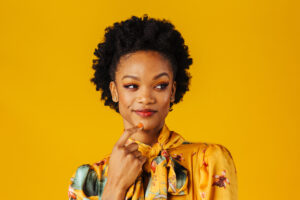 Portrait of a happy excited young woman smiling and looking to side in an elegant floral fashion top