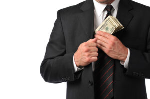 Businessman Pocketing a Stack of Money into His Suit Coat