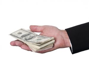 hand holding stack of 100 dollar bills
