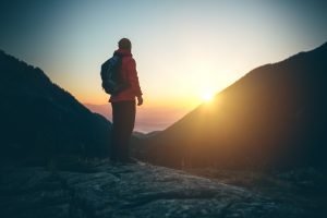 Silhouette of mountaineer on top of the mountain