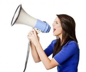 Pretty woman shouts into a megaphone, possibly protesting