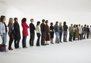 Row of people standing in line, rear view (digital enhancement)