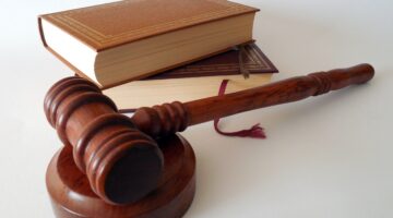 Close-up of a judge’s gavel near a law book, symbolizing legal expertise, court proceedings, litigation, legal research, and the practice of law for attorneys, law firms, and legal professionals.