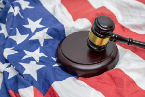 Wooden judge gavel and soundboard laying over US flag. Hammer and gavel. American law and justice concept. bidding concept.