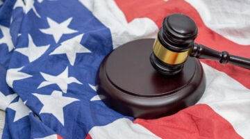 Wooden judge gavel and soundboard laying over US flag. Hammer and gavel. American law and justice concept. bidding concept.